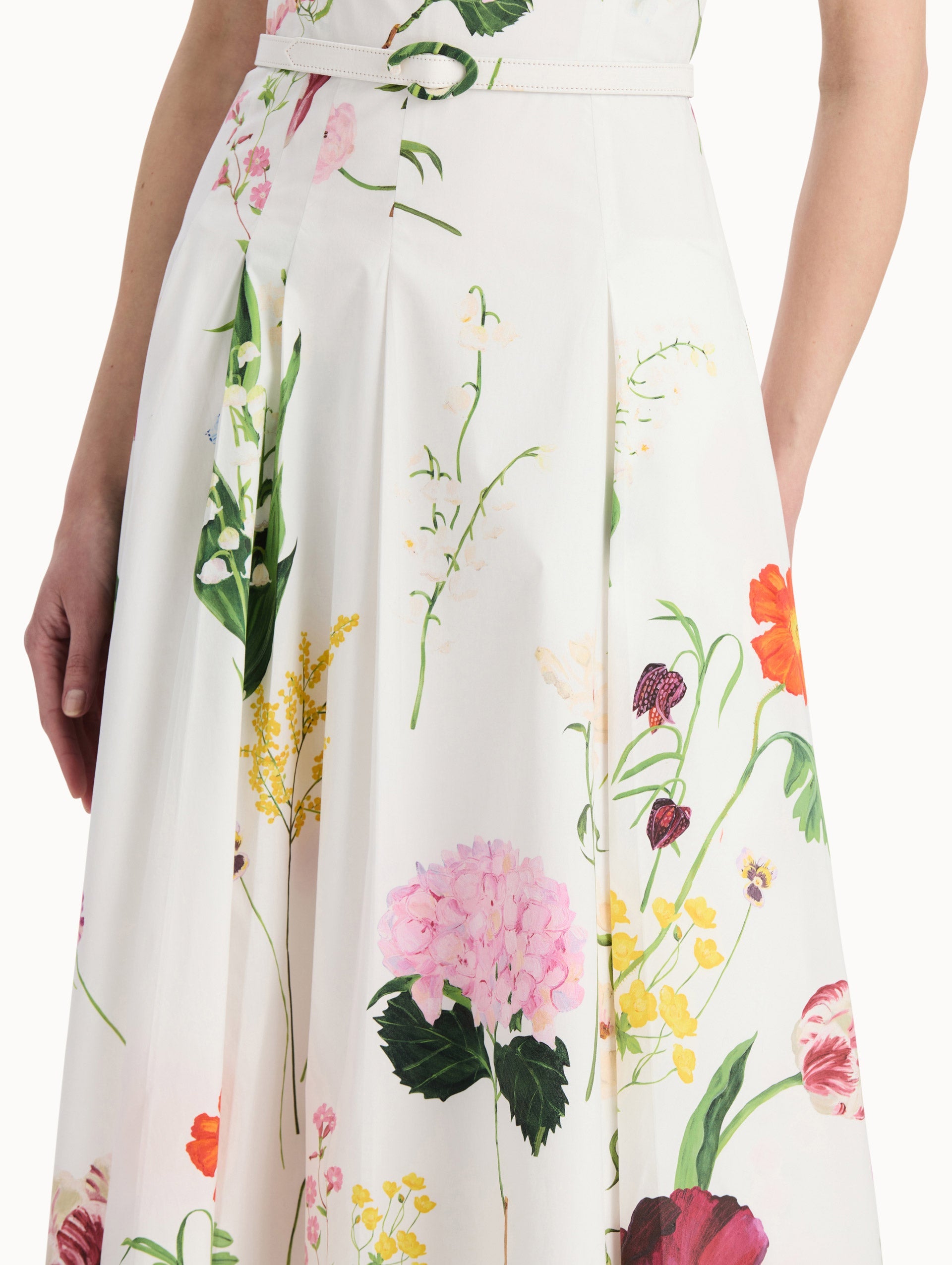 The model is wearing the mixed botanical cotton poplin sleeveless dress with an all-over floral print in white multi. Zoom view.
