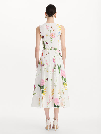 The model is wearing the mixed botanical cotton poplin sleeveless dress with an all-over floral print in white multi. Back view.