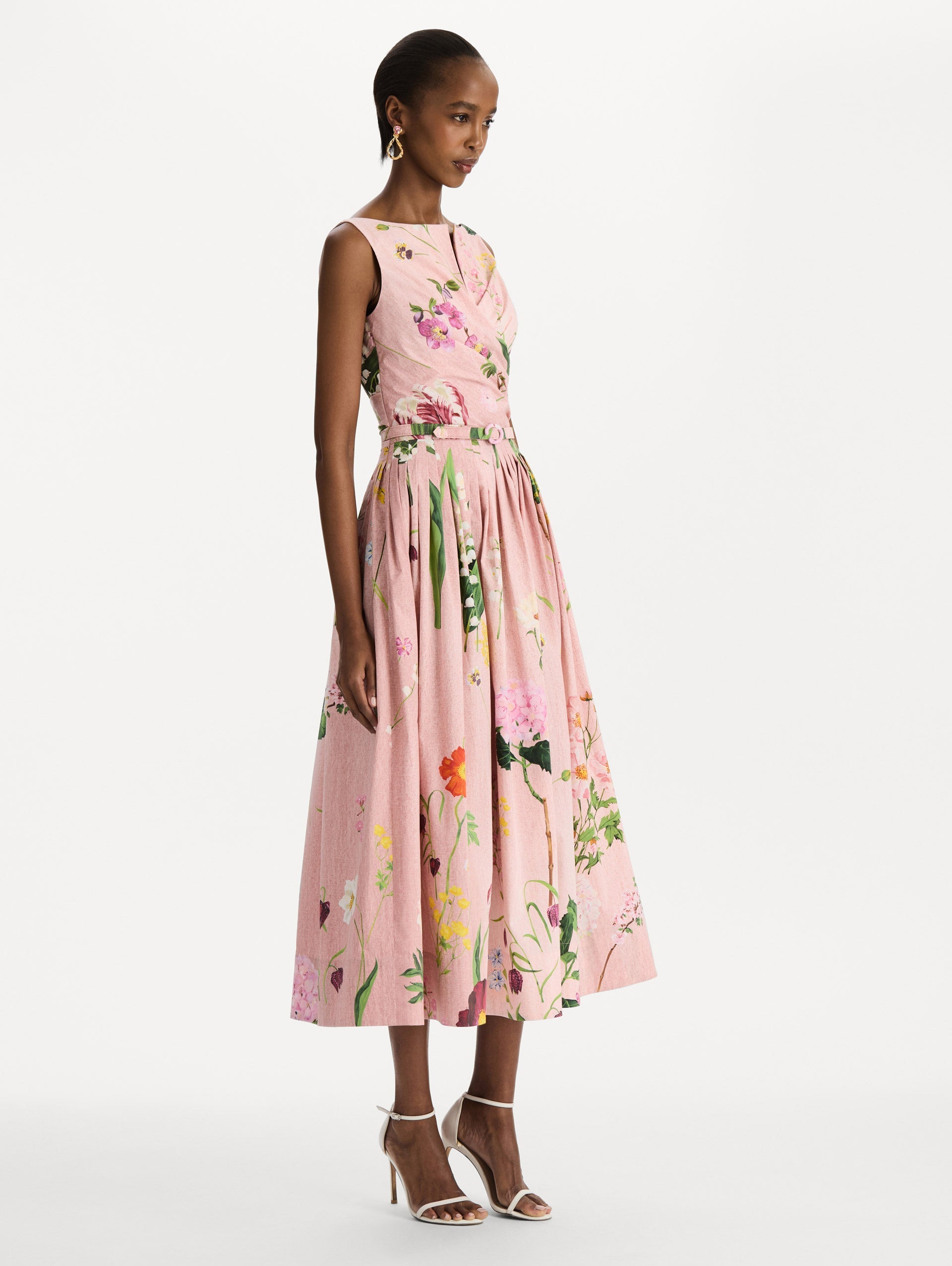 The model is wearing the mixed botanical cotton poplin draped dress with waist detailing and an all-over floral print in blush multi. Side view.