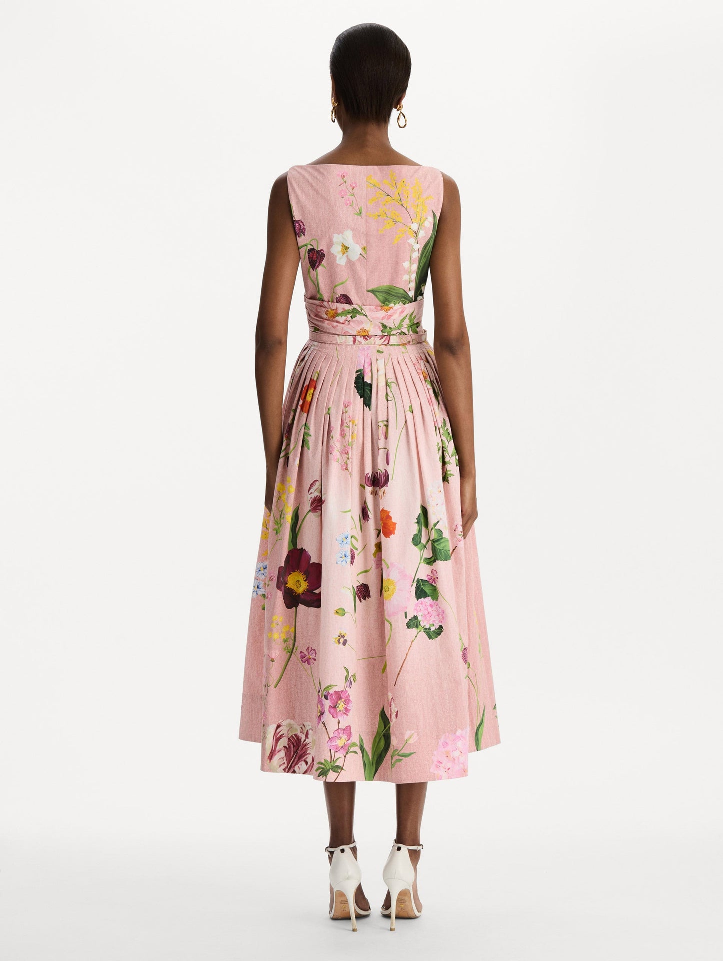 The model is wearing the mixed botanical cotton poplin draped dress with waist detailing and an all-over floral print in blush multi. Back view.