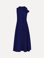 The model is wearing the Bow-Detailed Wool Dress with a sleeveless silhouette in the color navy.