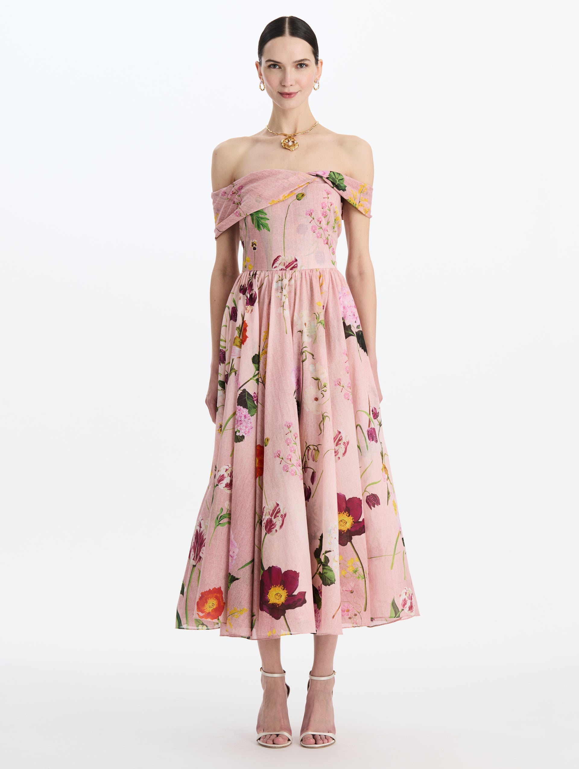The model is wearing the mixed botanical off-shoulder dress in organic cotton with a floral print in a blush multi palette. Front view.