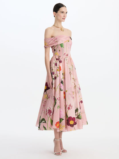 The model is wearing the mixed botanical off-shoulder dress in organic cotton with a floral print in a blush multi palette. Side view.