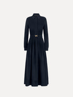 The model is wearing the bow belt cotton stretch twill dress with a collared neckline and long sleeves in the color navy.