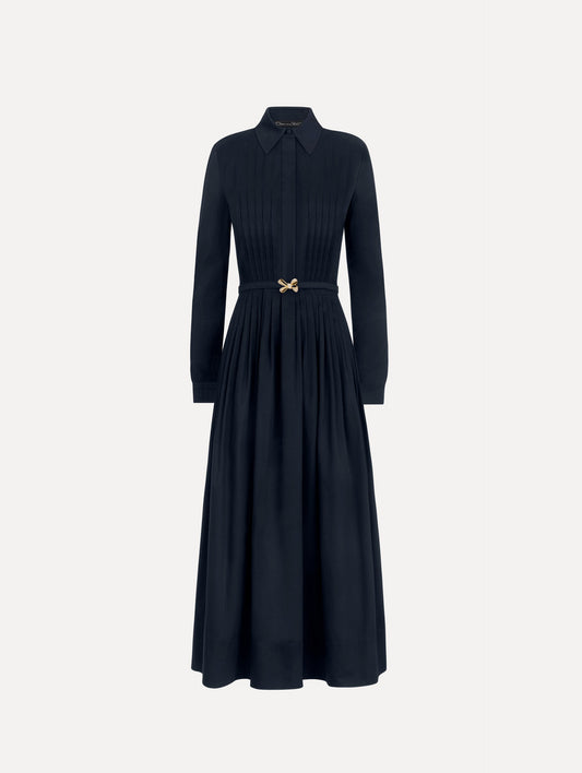 The model is wearing the bow belt cotton stretch twill dress with a collared neckline and long sleeves in the color navy.