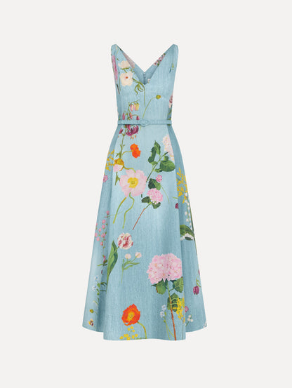 The model is wearing the mixed botanical cotton poplin dress with a sleeveless V-neck silhouette and an all-over floral print in blue multi.