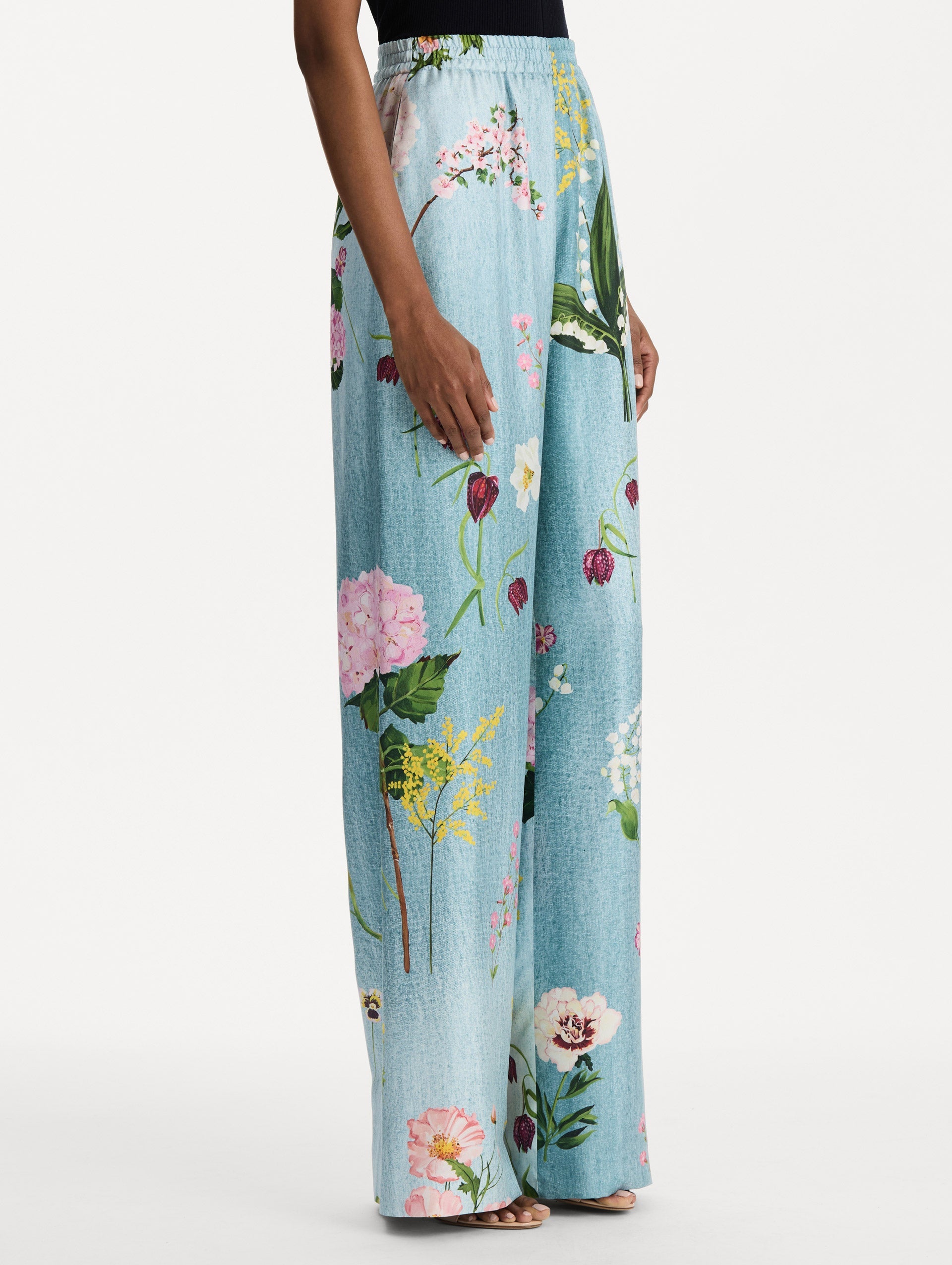 The model is wearing the mixed botanical silk twill pant in the color blue multi. Side view.