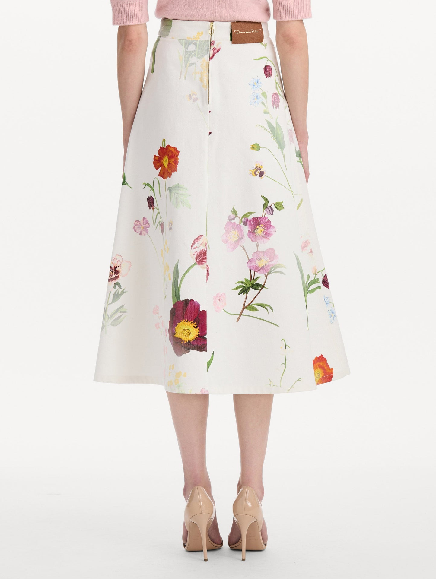 The model is wearing the faded mixed botanical denim midi skirt in the color white multi. Back view.