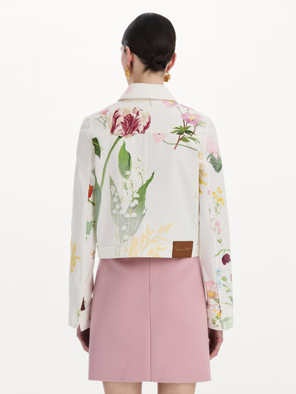 The model is wearing the faded mixed botanical denim jacket in the color white multi. Back view.