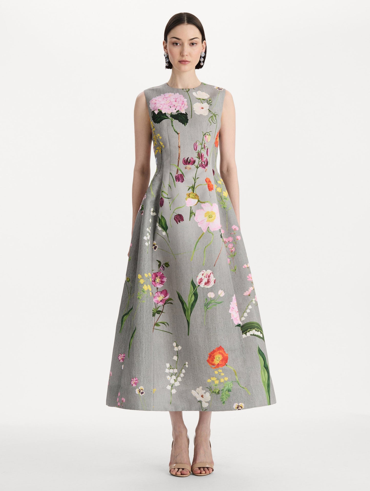 The model is wearing the mixed botanical faille cocktail dress with a sleeveless silhouette in the color grey multi. Front view.
