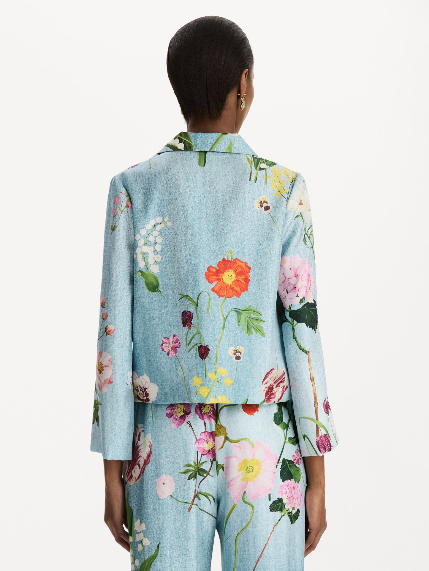 The model is wearing the mixed botanical silk twill blouse with long sleeves in the color blue multi. Back view.