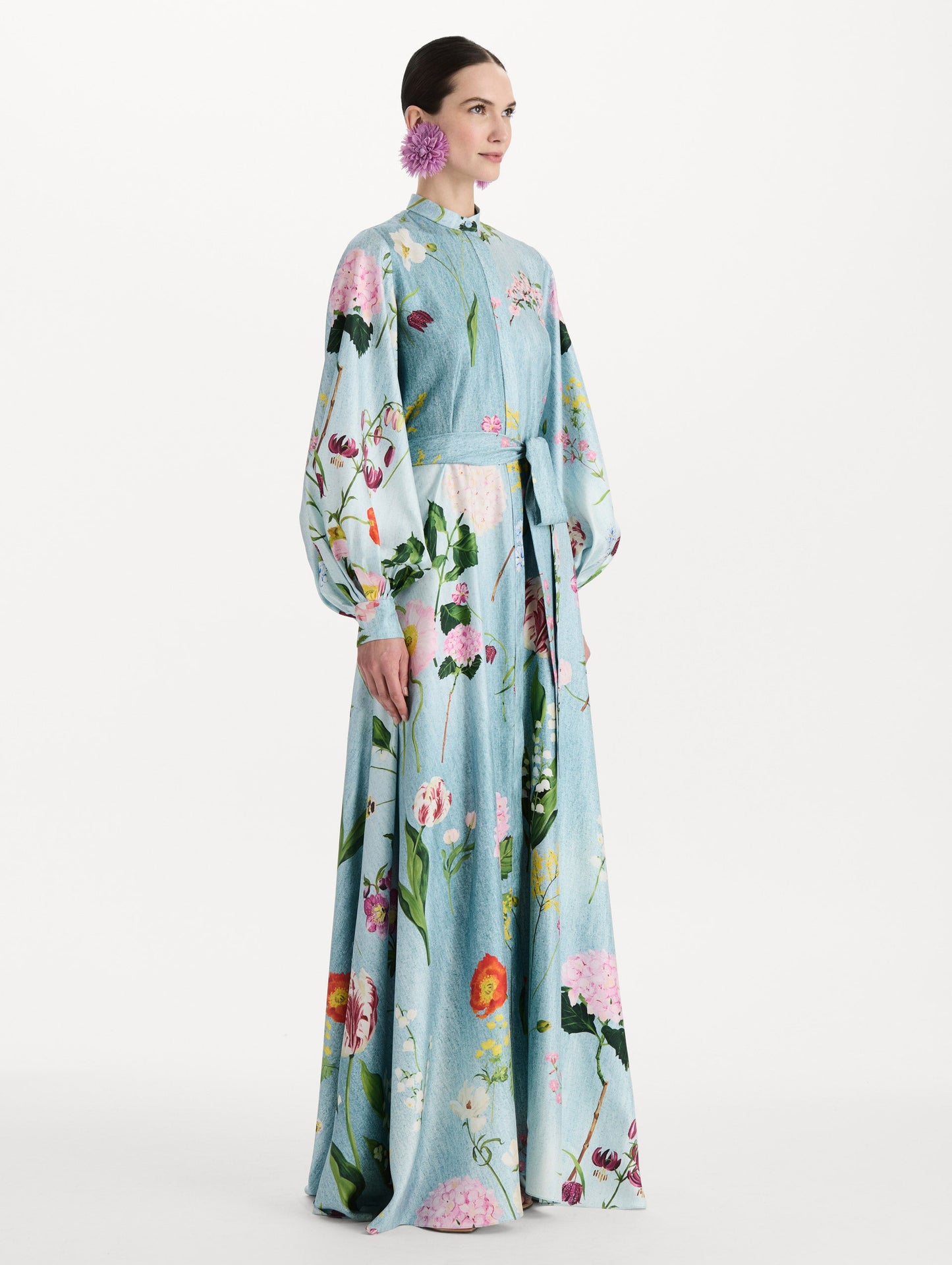 The model is wearing the mixed botanical silk twill caftan with long sleeves in blue multi. Side view.
