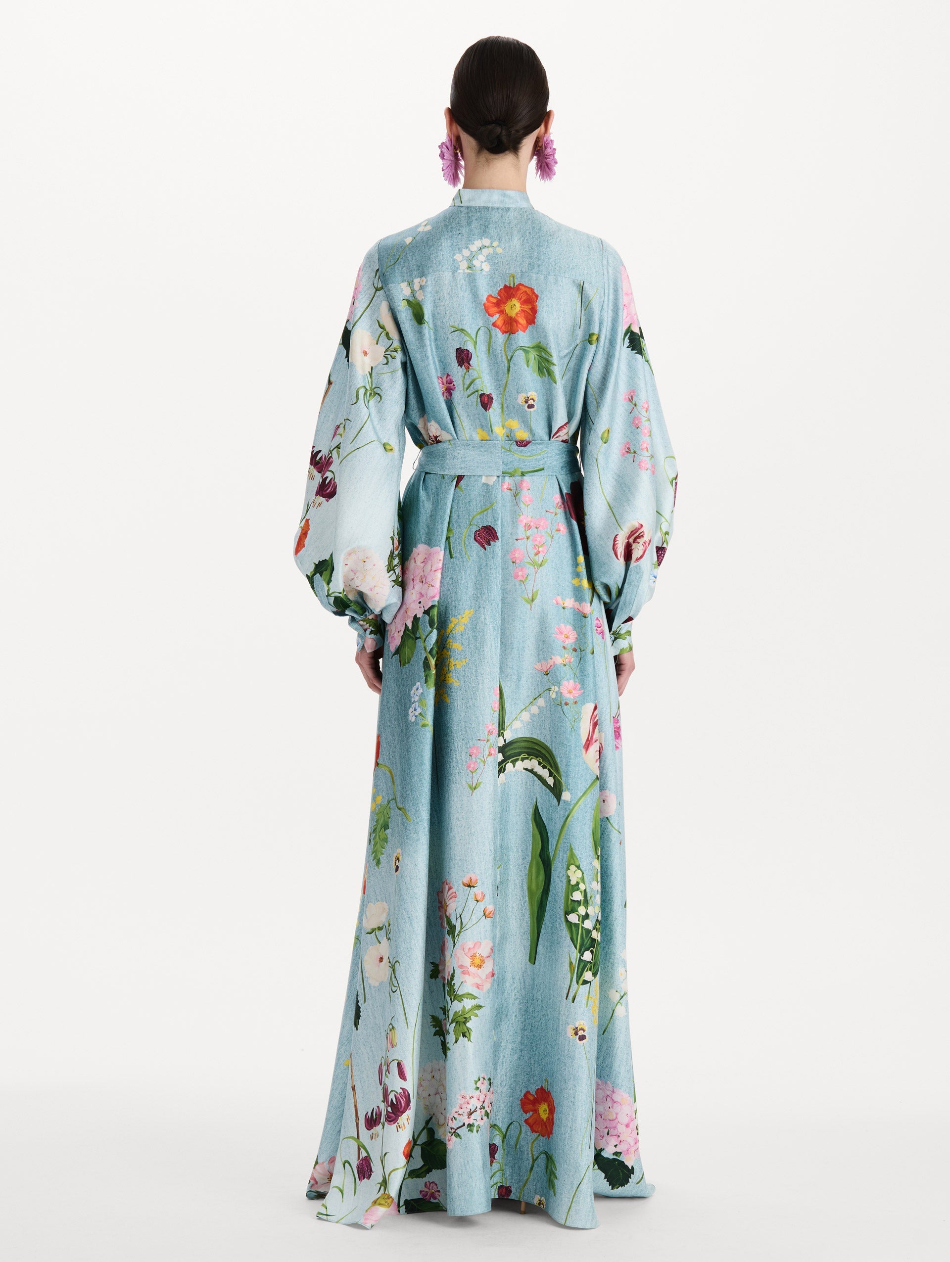 The model is wearing the mixed botanical silk twill caftan with long sleeves in blue multi. Back view.