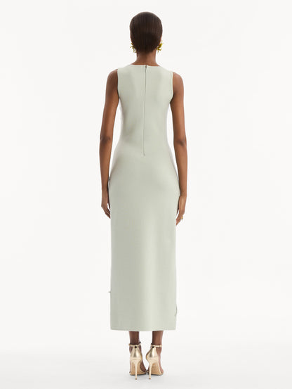 The model is wearing the Hibiscus Embroidered Knit Pencil Dress in Saltwater Blue. Featuring a structural hibiscus embroidery, a scoop neckline, and midi length. Back View.