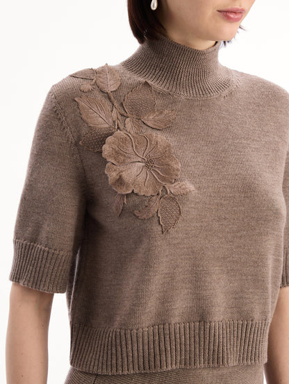 The model is wearing the Hibiscus Embroidered Knit Pullover. Featuring a high neckline and ribbed trim. Detail View.