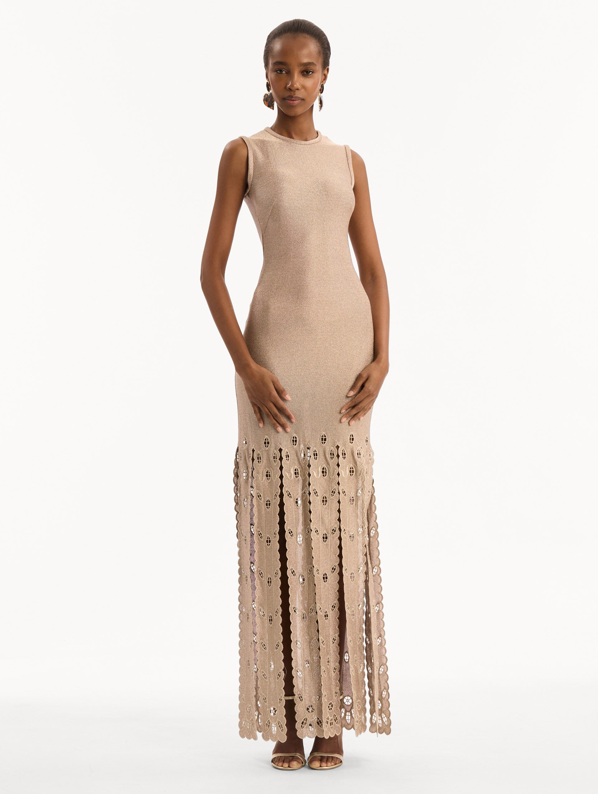 The model is wearing the Pineapple Fringe Metallic Jersey Dress. Featuring shimmering metallic jersey fabrication, a body-skimming silhouette, and pineapple-inspired fringe along the hem. Front View.