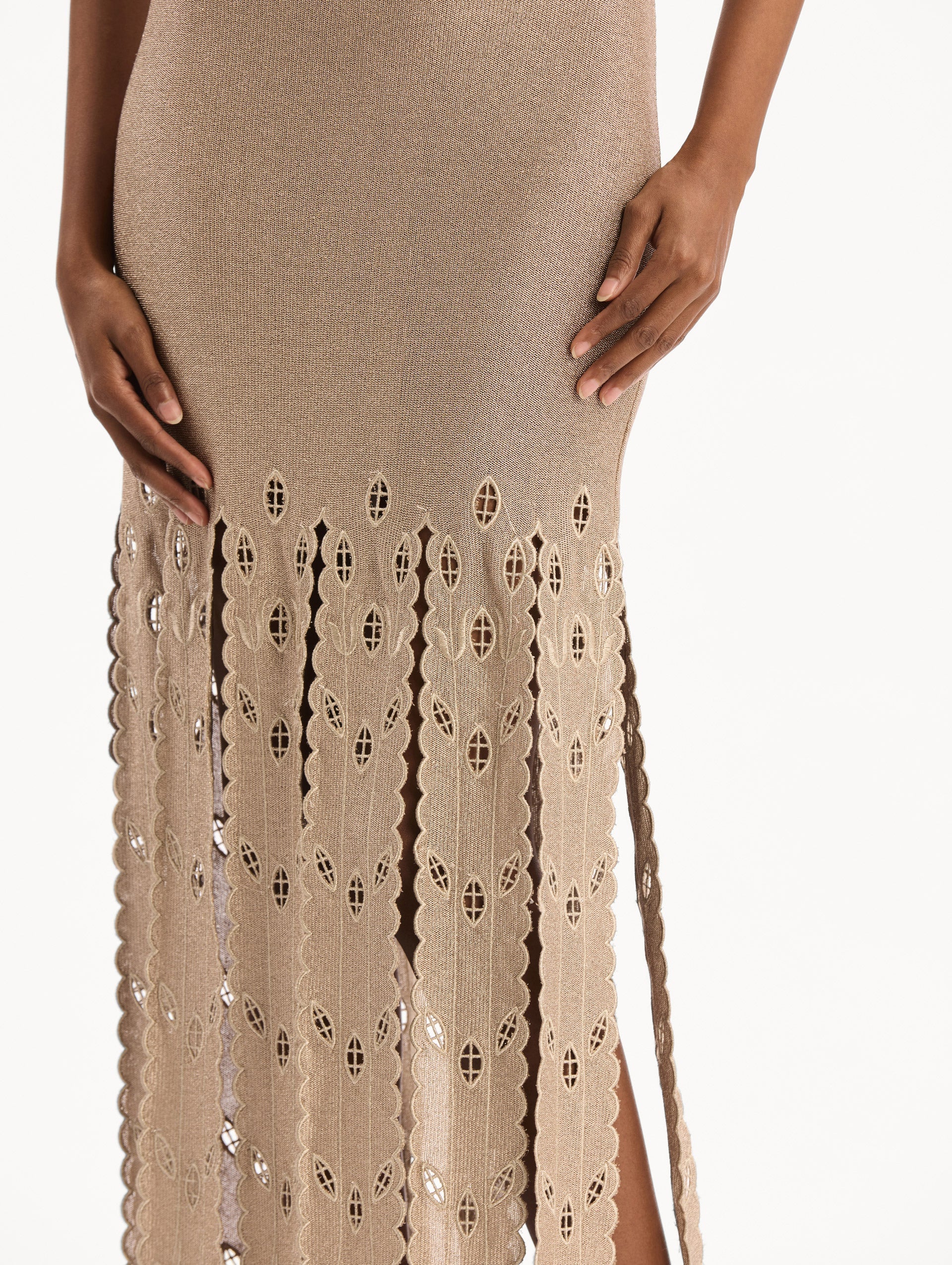 The model is wearing the Pineapple Fringe Metallic Jersey Dress. Featuring shimmering metallic jersey fabrication, a body-skimming silhouette, and pineapple-inspired fringe along the hem. Detail View.