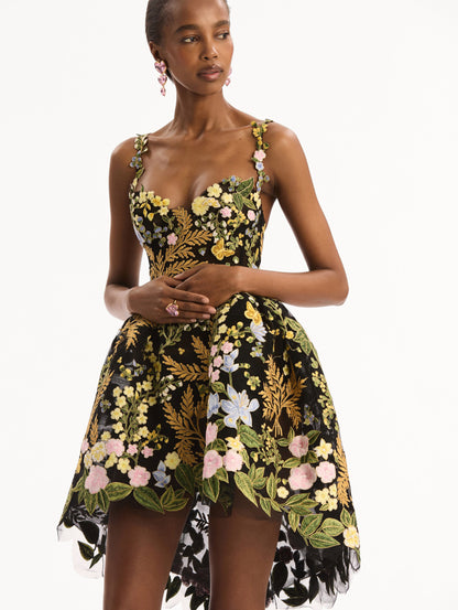 The model is wearing the Dominican Mixed-Floral Guipure High-Low Dress. Featuring a sweetheart neckline, delicate floral straps, fitted bodice, and mini skirt. Detail View.