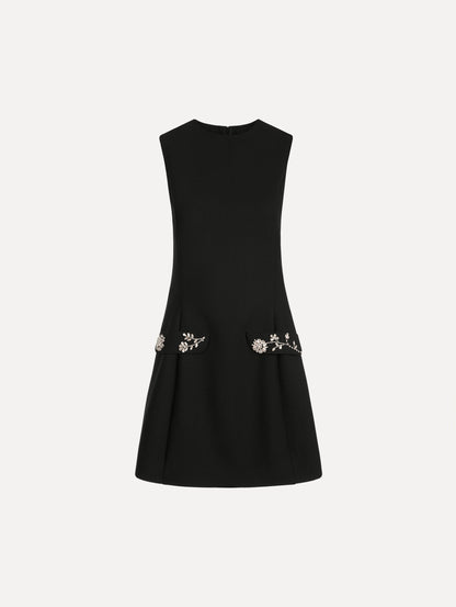 The Crystal Floral Embroidered Cocktail Dress in Black. Featuring faux front flap pockets with crystal embroidery and a structured mini skirt. Front View.