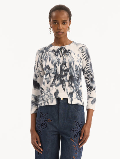 The model is wearing the Chiné Palm Leaves Cardigan in Navy and White. Featuring a crew neckline, quarter-length sleeves, banded trim, and tie front closure. Front View.