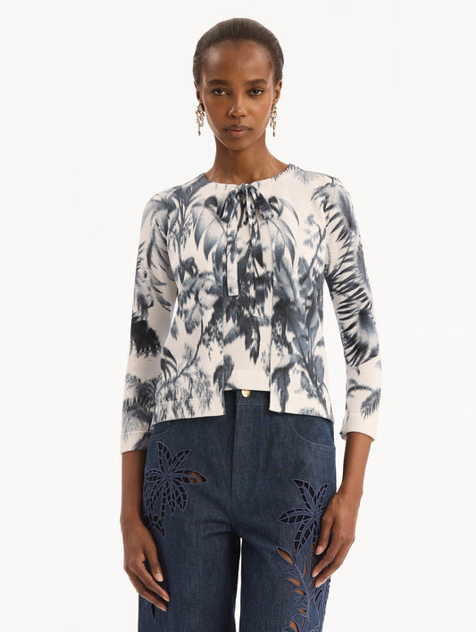 The model is wearing the Chiné Palm Leaves Cardigan in Navy and White. Featuring a crew neckline, quarter-length sleeves, banded trim, and tie front closure. Front View.