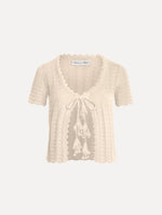 The Pointelle Weave Cardigan in Ivory. Featuring a scoop neckline, short sleeves, scalloped edges, and a front tie closure. Front View.