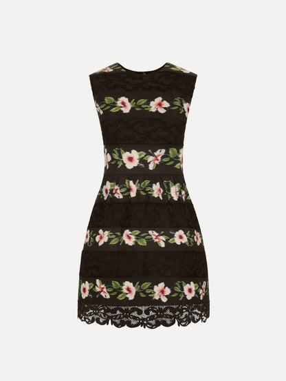 The Chiné Hibiscus Striped Faille Dress in Black. Featuring woven hibiscus motifs alternating with panels of faille and guipure lace, creating a striped pattern. Mini length. Front View.