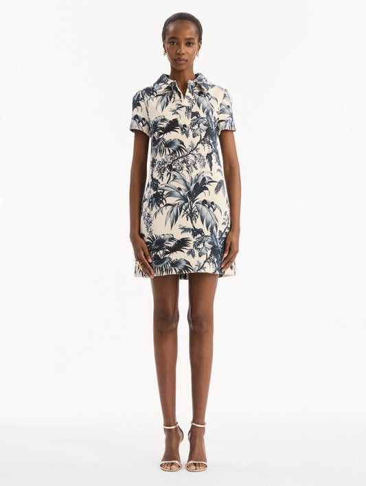 The model is wearing the Chiné Palm Leaves Shift Dress in ivory printed with navy palm leaves. Featuring a classic collar neckline, short sleeves, and mini length. Front View.