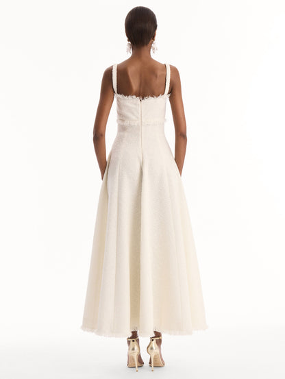 The model is wearing the Slub Wool Tweed Midi Dress in Ivory. Featuring a softly structured silhouette and curved neckline accented with delicate fringe detailing. Back View.