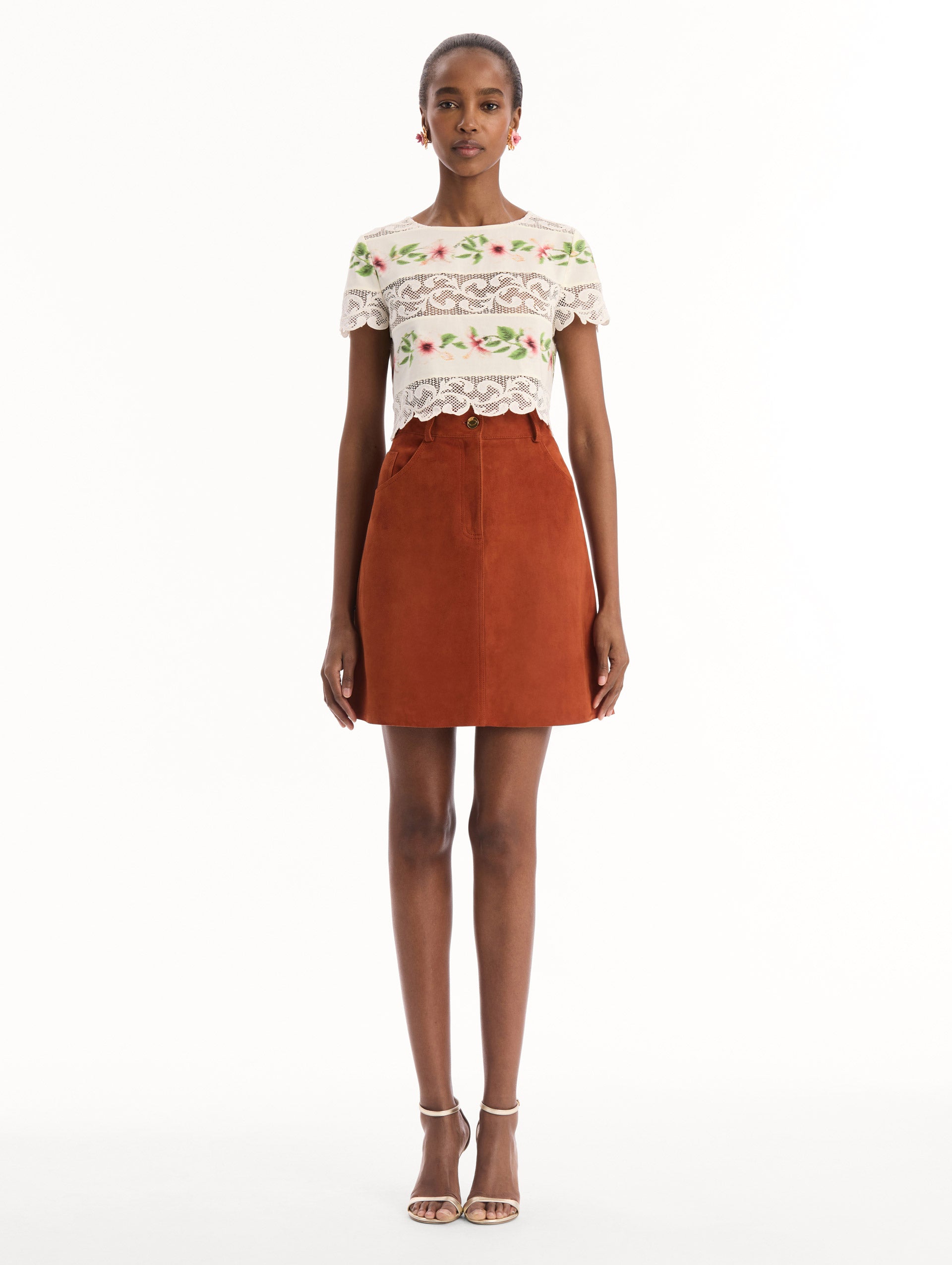 The model is wearing the chiné hibiscus striped cotton poplin blouse with guipure lace panels and a striped floral pattern in the color ivory. Front view.