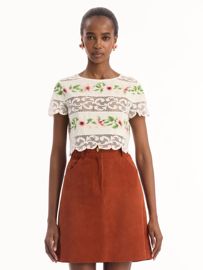 The model is wearing the chiné hibiscus striped cotton poplin blouse with guipure lace panels and a striped floral pattern in the color ivory. Front view.