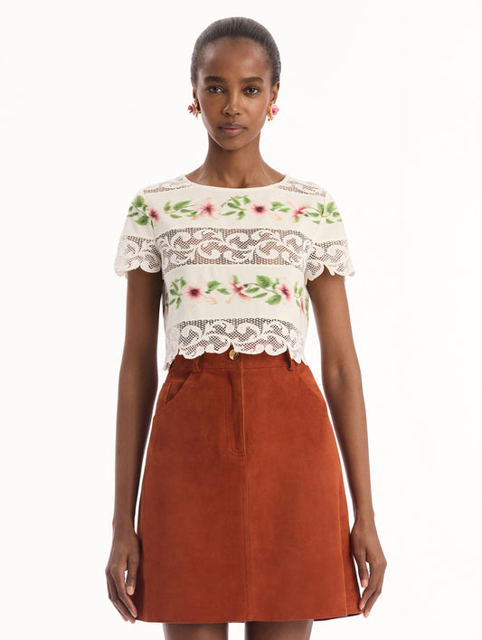 The model is wearing the chiné hibiscus striped cotton poplin blouse with guipure lace panels and a striped floral pattern in the color ivory. Front view.