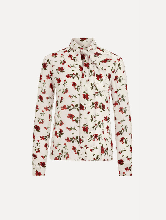 The Hibiscus Silk Chiffon Blouse in white printed with red hibiscus florals. Featuring a tie at neckline, long sleeves, and tailored silhouette. Front View.
