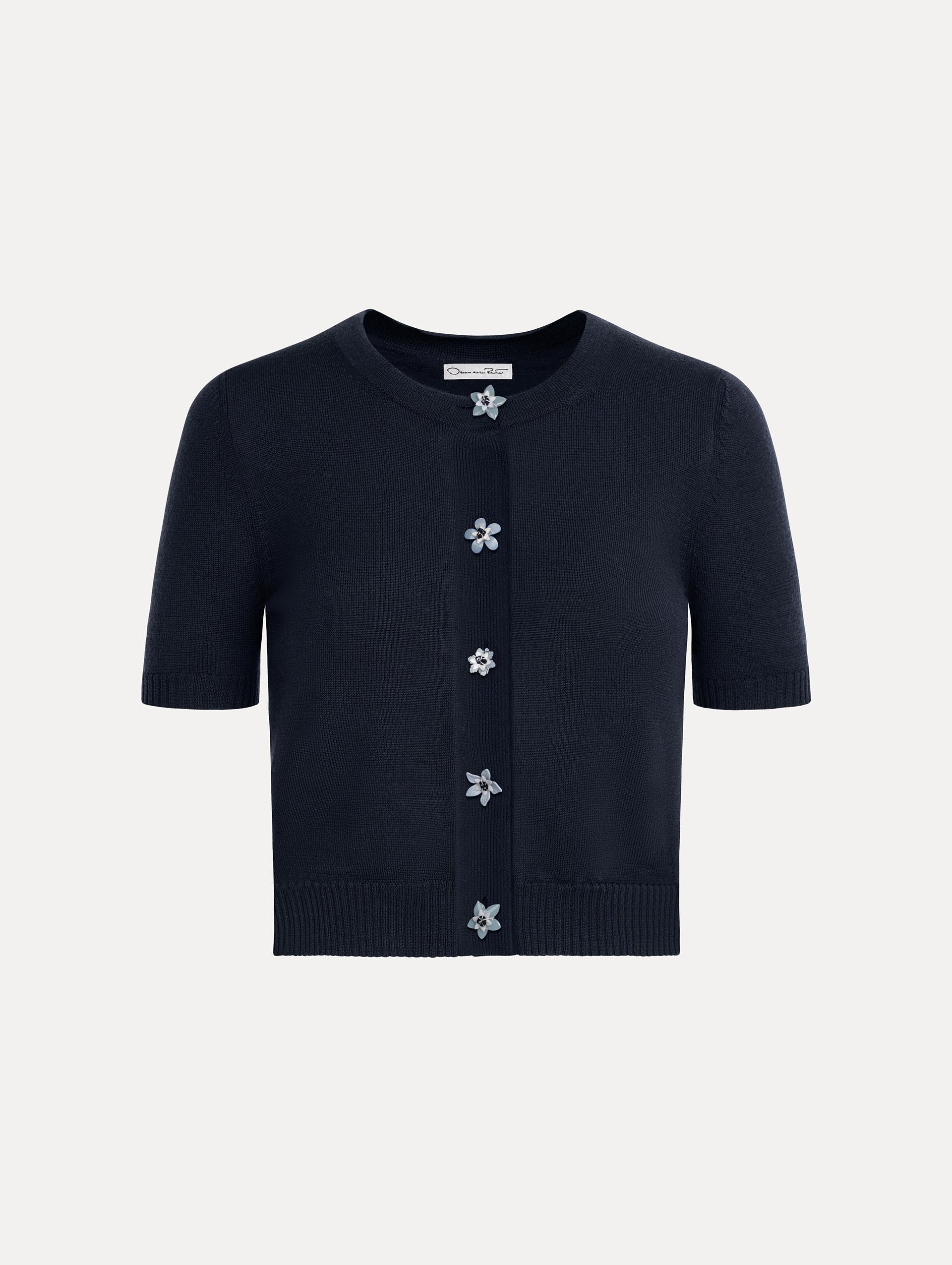 Cropped navy crew neck cardigan, short sleeves, floral buttons. Front View.