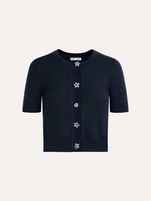 Cropped navy crew neck cardigan, short sleeves, floral buttons. Front View.