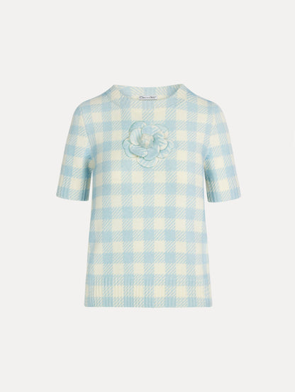 Short sleeve Knit pullover in classic pale blue and white gingham wool. Dimensional floral appliqué at the neckline. Front View.