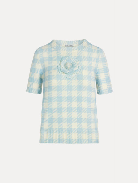 Short sleeve Knit pullover in classic pale blue and white gingham wool. Dimensional floral appliqué at the neckline. Front View.