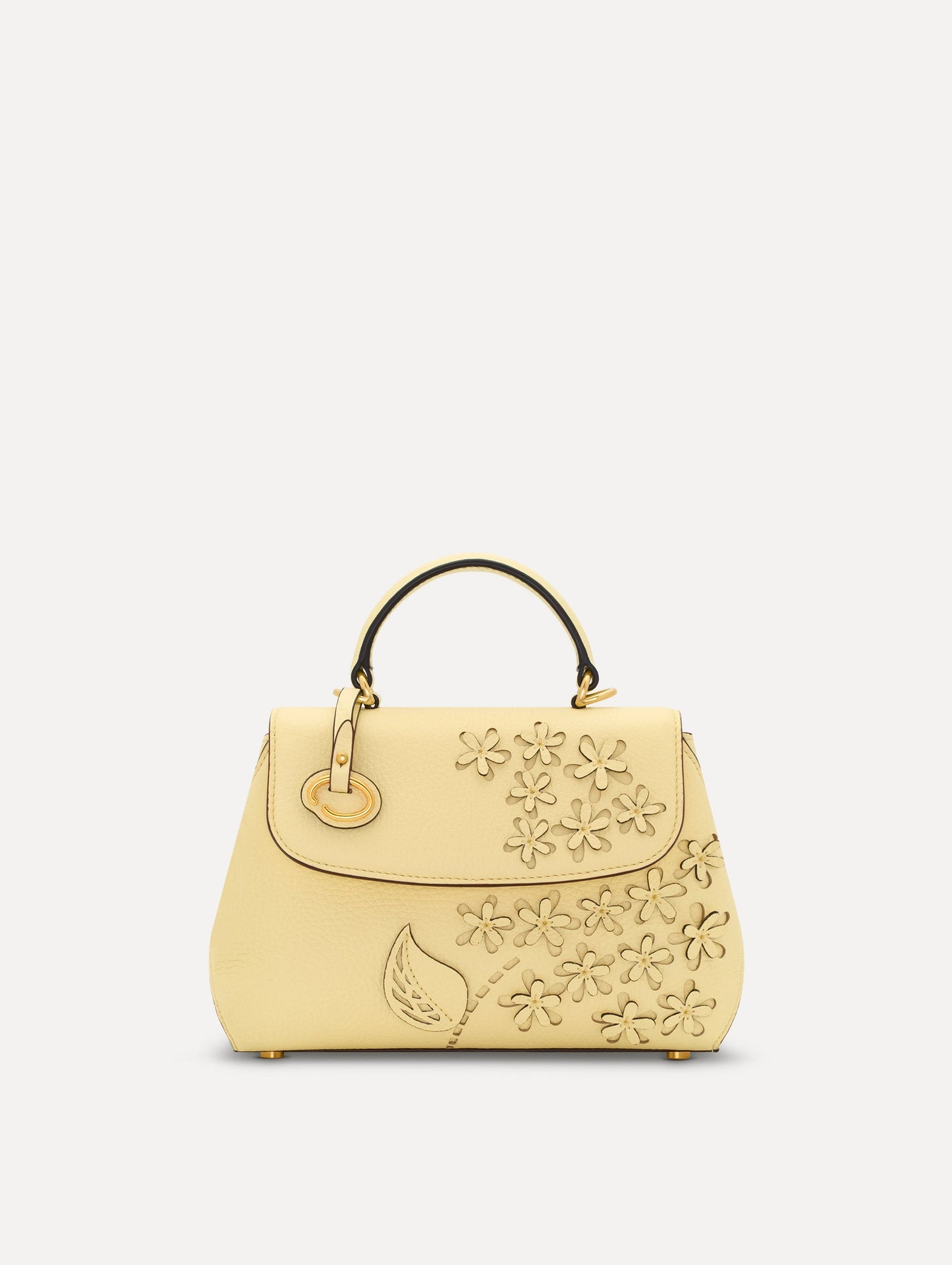 The Mini Poppy in yellow with floral cutout designs and gold hardware. Front View.