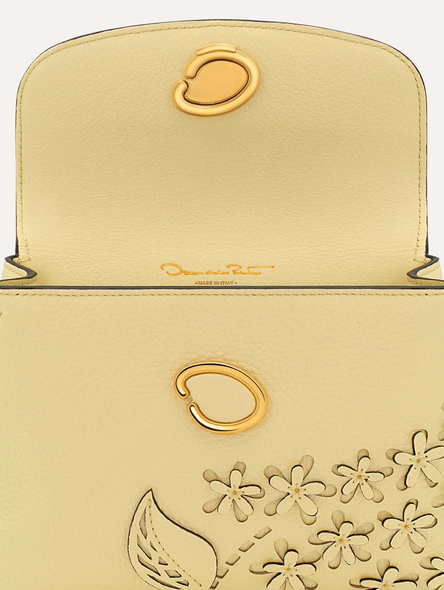 The Mini Poppy in yellow with floral cutout designs and gold hardware. Zoom View.