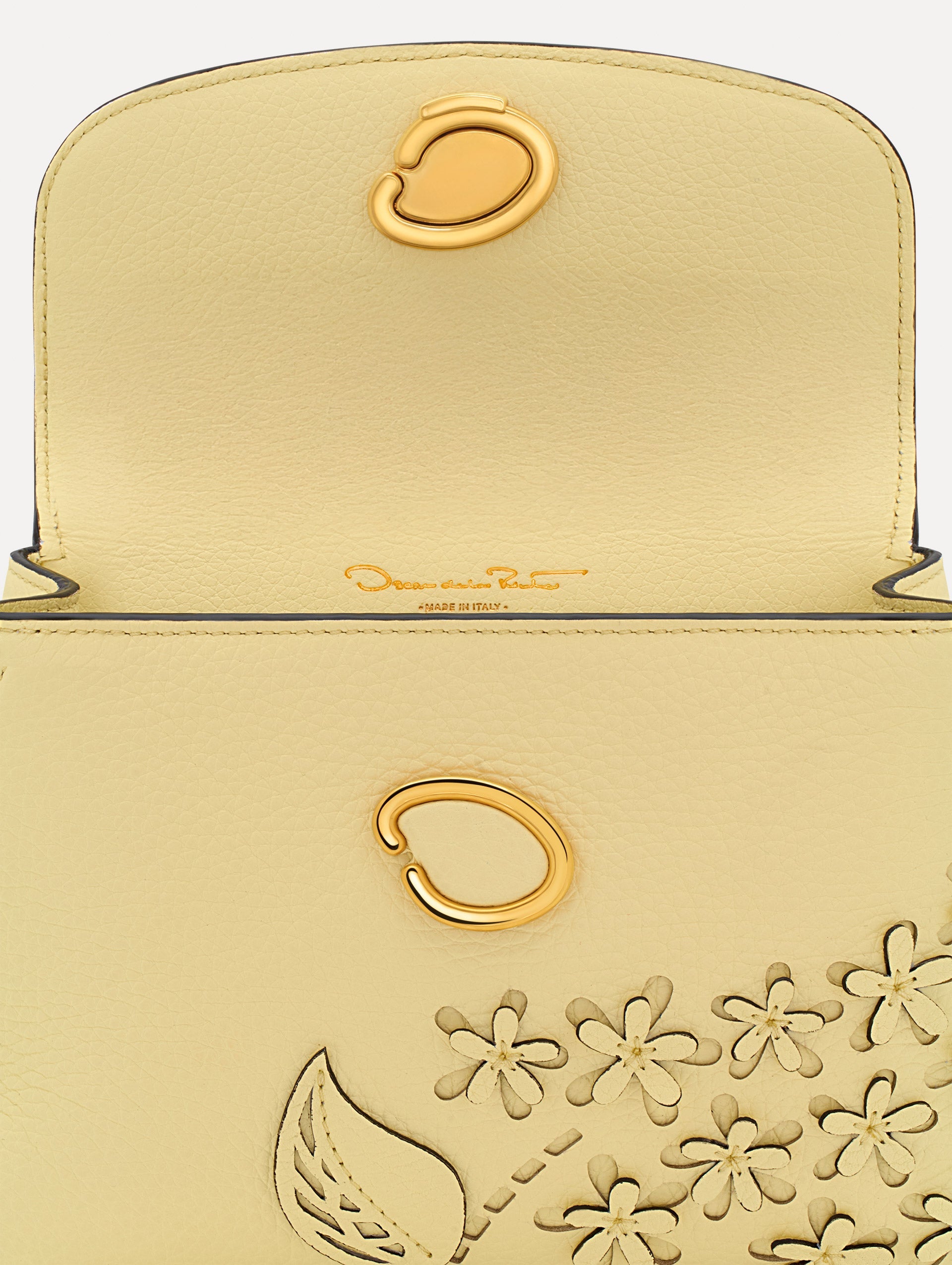 The Mini Poppy in yellow with floral cutout designs and gold hardware. Zoom View.