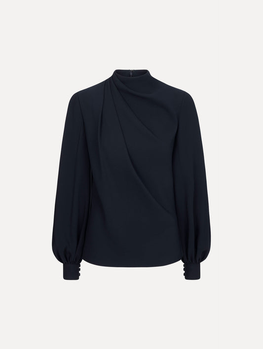 The model is wearing the Draped Georgette Blouse in the color Navy. Featuring silk georgette, a draping mock-neckline, and long, billowed sleeves. Front View.