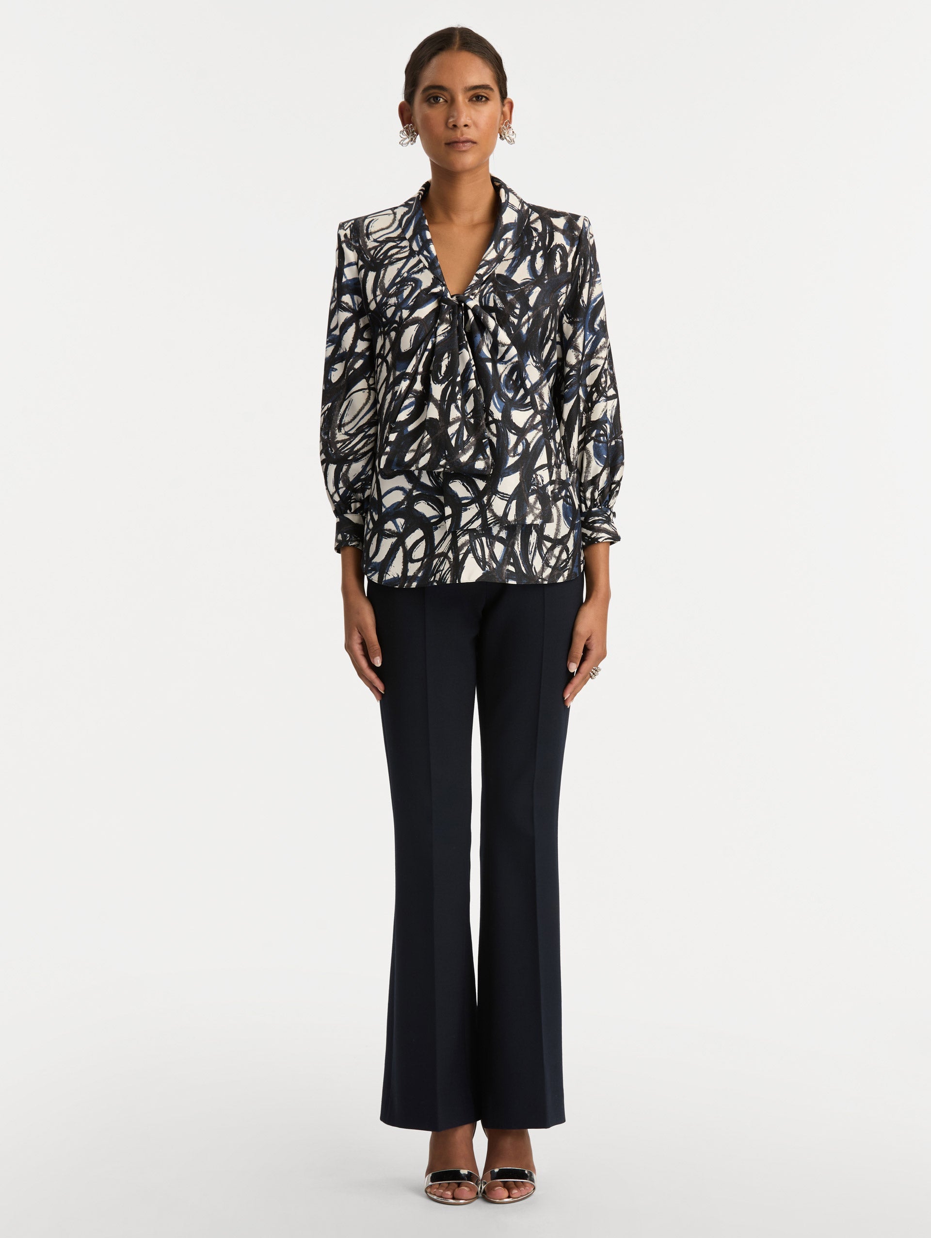 White and Blue Abstract Sketch Silk Twill Blouse featuring a deep V-neckline with knotted drape detail and long sleeves. Front View.