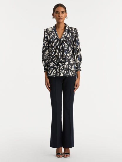 White and Blue Abstract Sketch Silk Twill Blouse featuring a deep V-neckline with knotted drape detail and long sleeves. Front View.