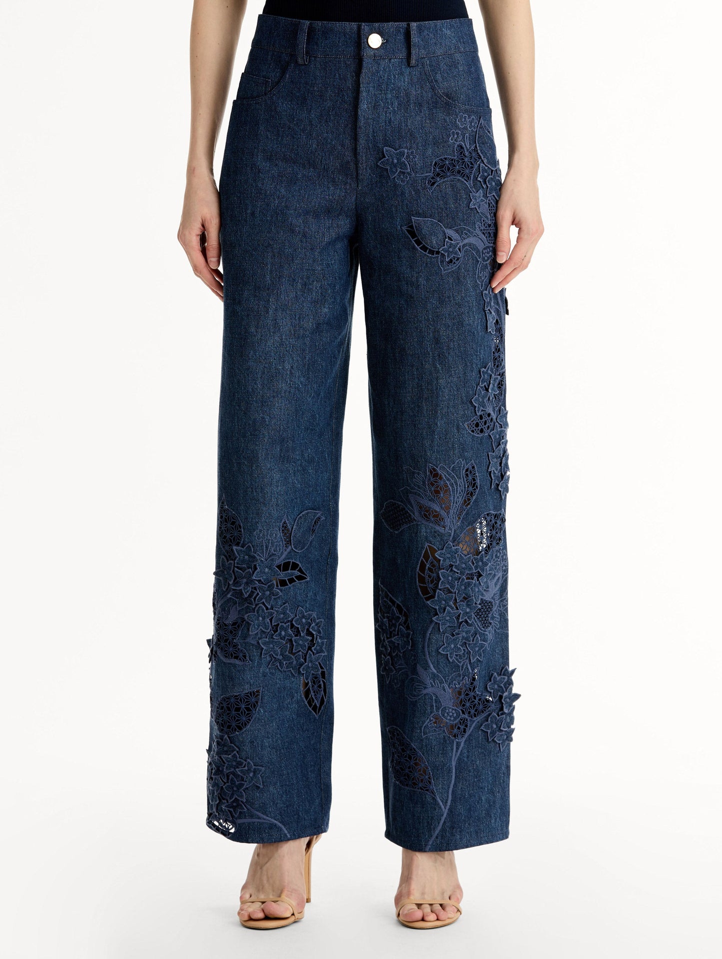 Mid-rise denim pants with intricate porcelain flower threadwork and cutout detailing. Front View, Close Up.
