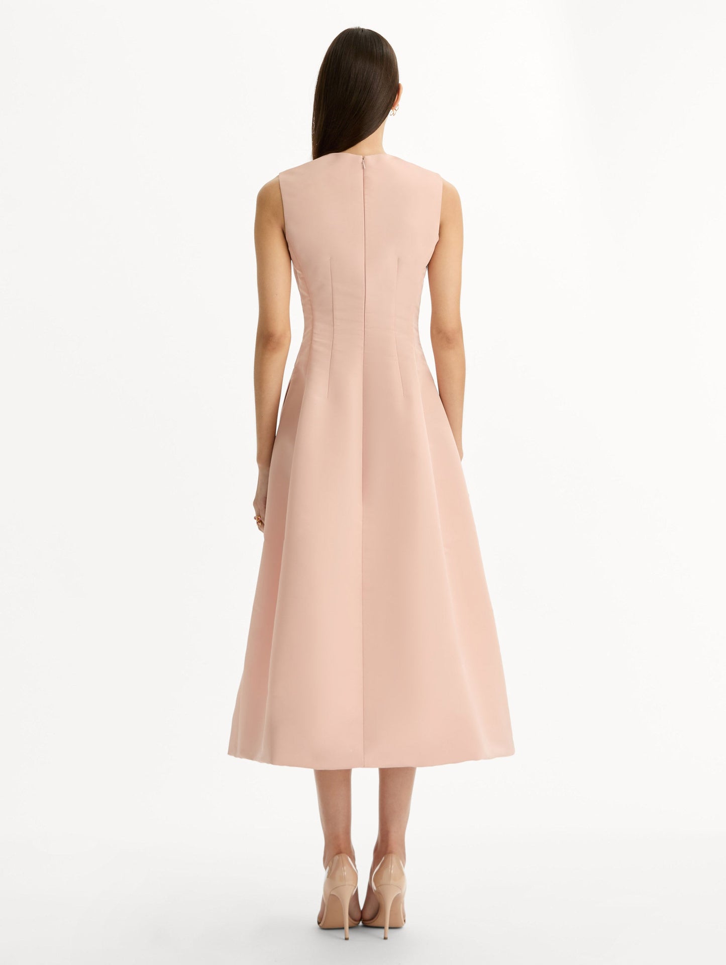 Blush pink cocktail midi dress. Centered, three dimensional hand-embroidered bouquet creating the illusion of a bouquet held close to the heart. Halter neck with flared skirt. Back View.