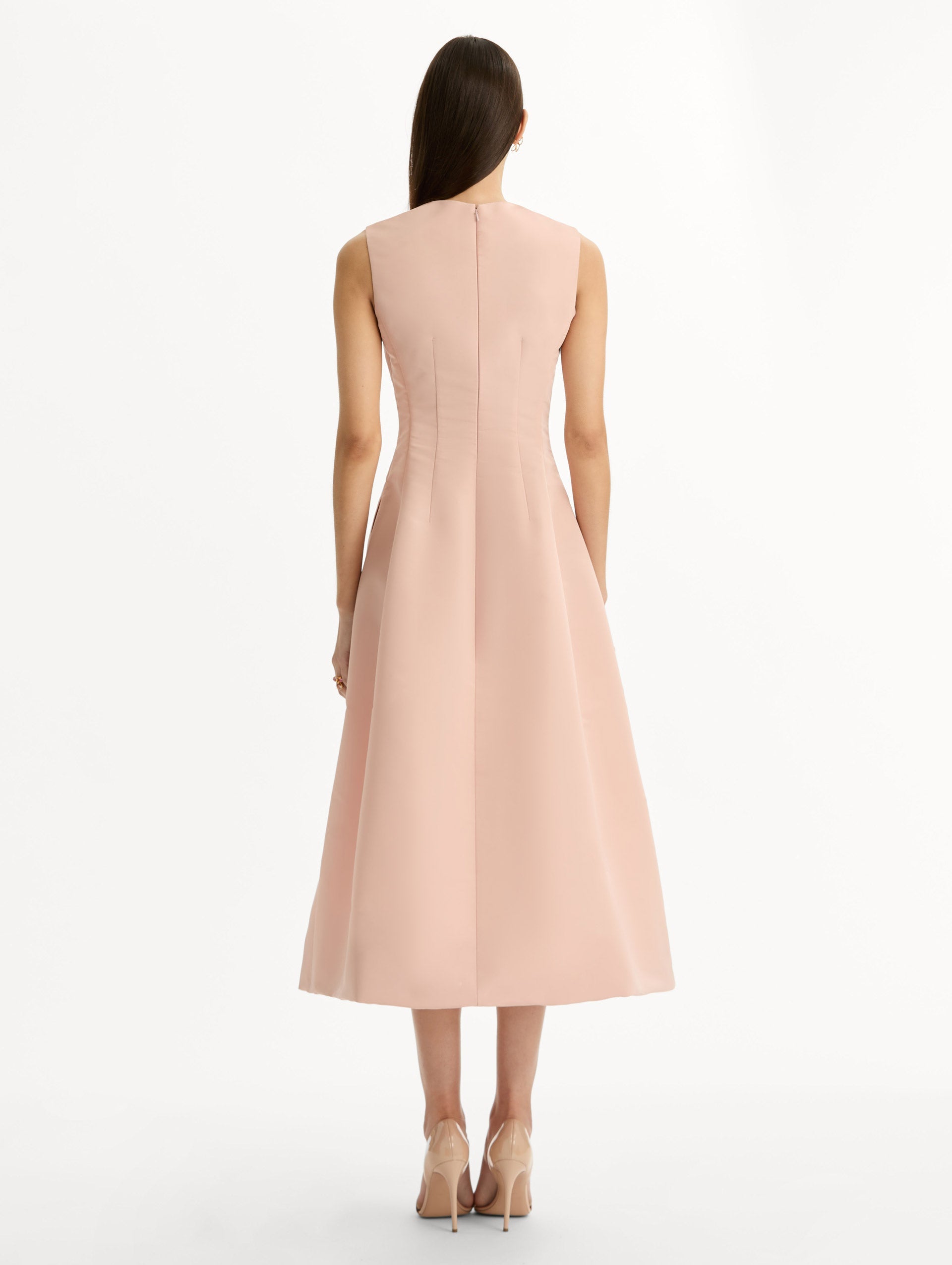 Blush pink cocktail midi dress. Centered, three dimensional hand-embroidered bouquet creating the illusion of a bouquet held close to the heart. Halter neck with flared skirt. Back View.