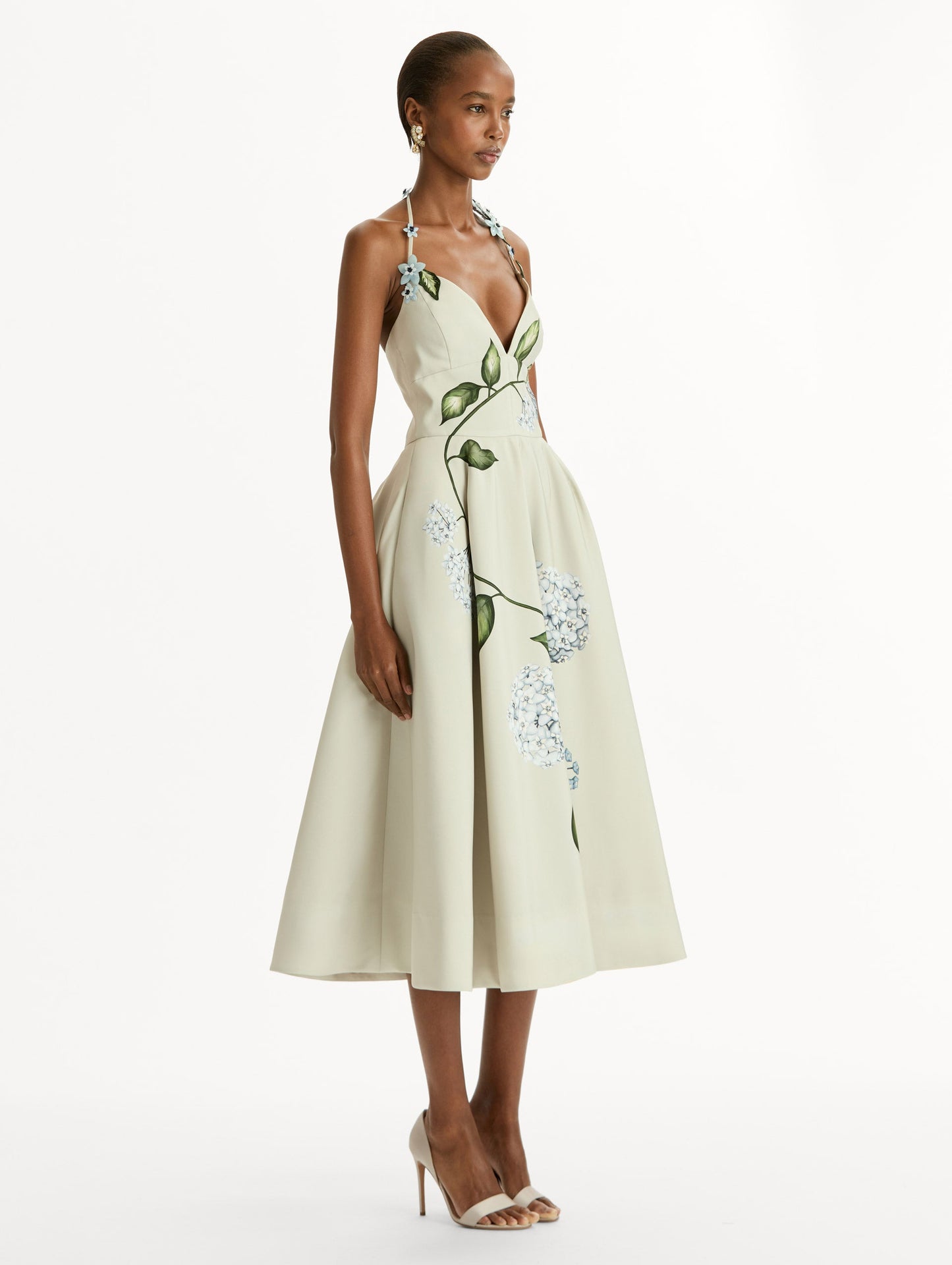 Porcelain flower-printed faille cocktail midi dress with floral appliqué halter neckline. Fitted bodice and full skirt. Side View.