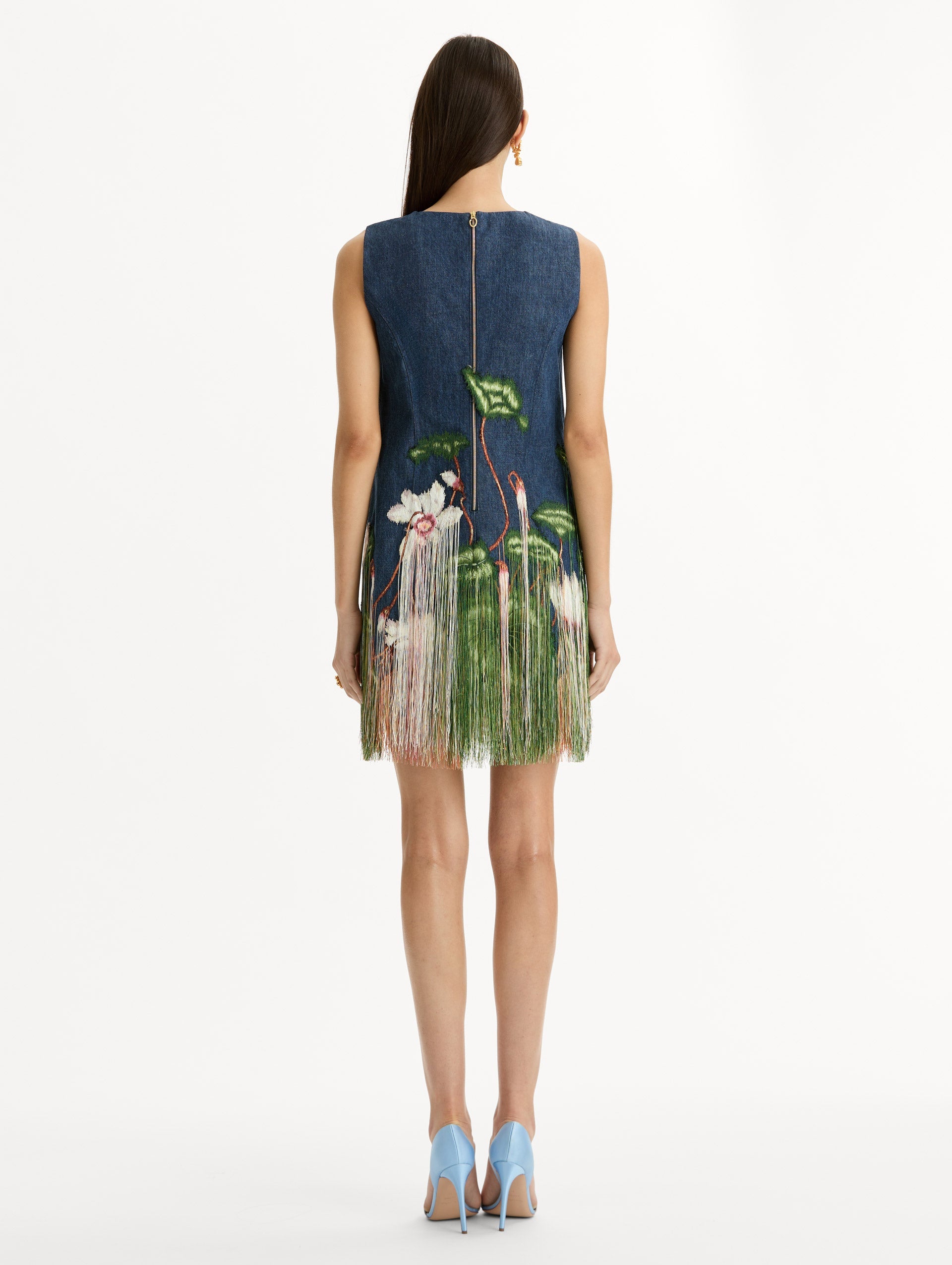 Denim, mini shift dress with Chiné Cyclamen motif and cascading threadwork fringe. Sleeveless. Zipper closure at back. Back View.
