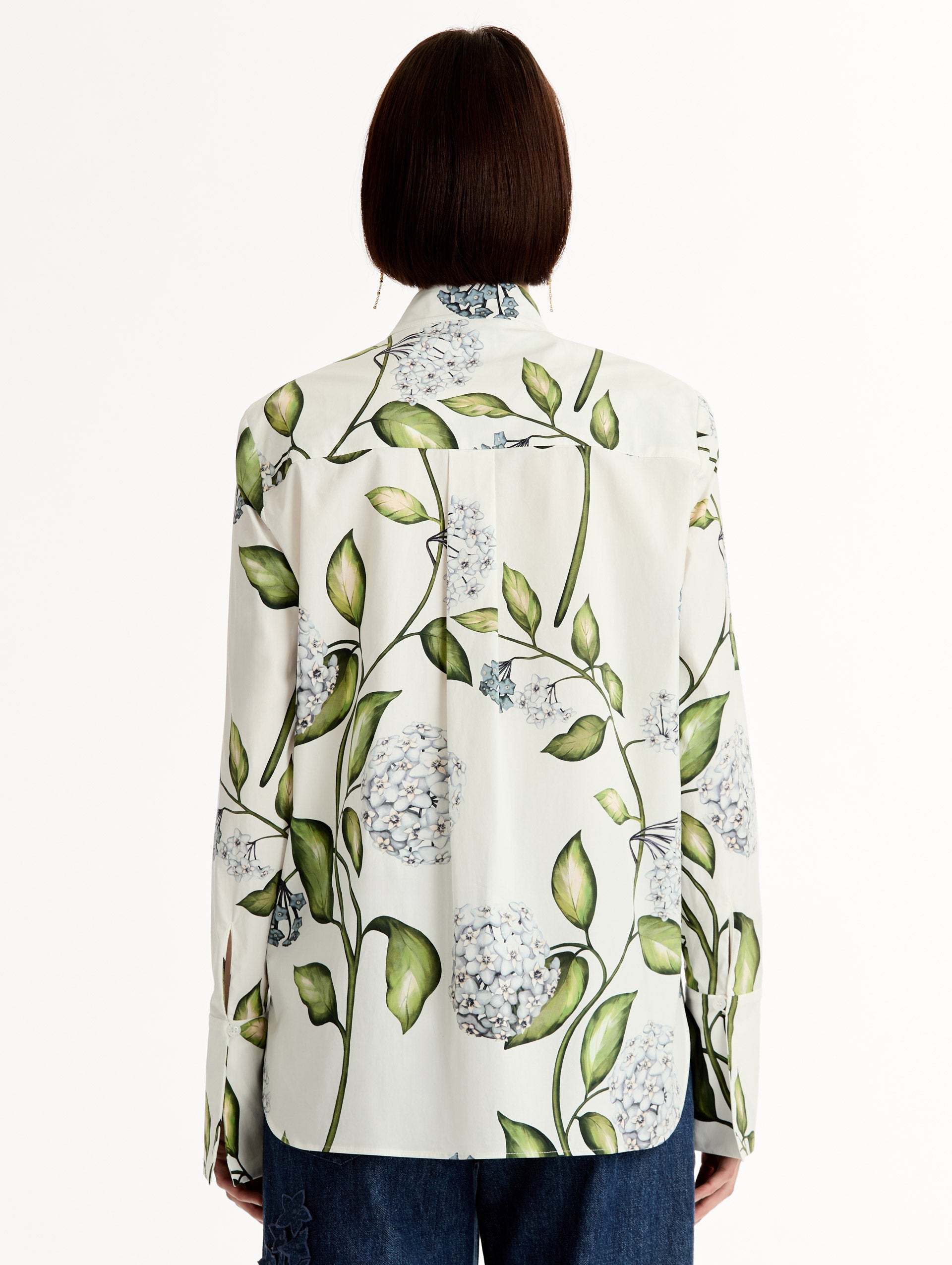 Porcelain flower print on cotton poplin blouse. Tailored silhouette and concealed button front. Threadwork cutout detailing. High Neckline. Back View.