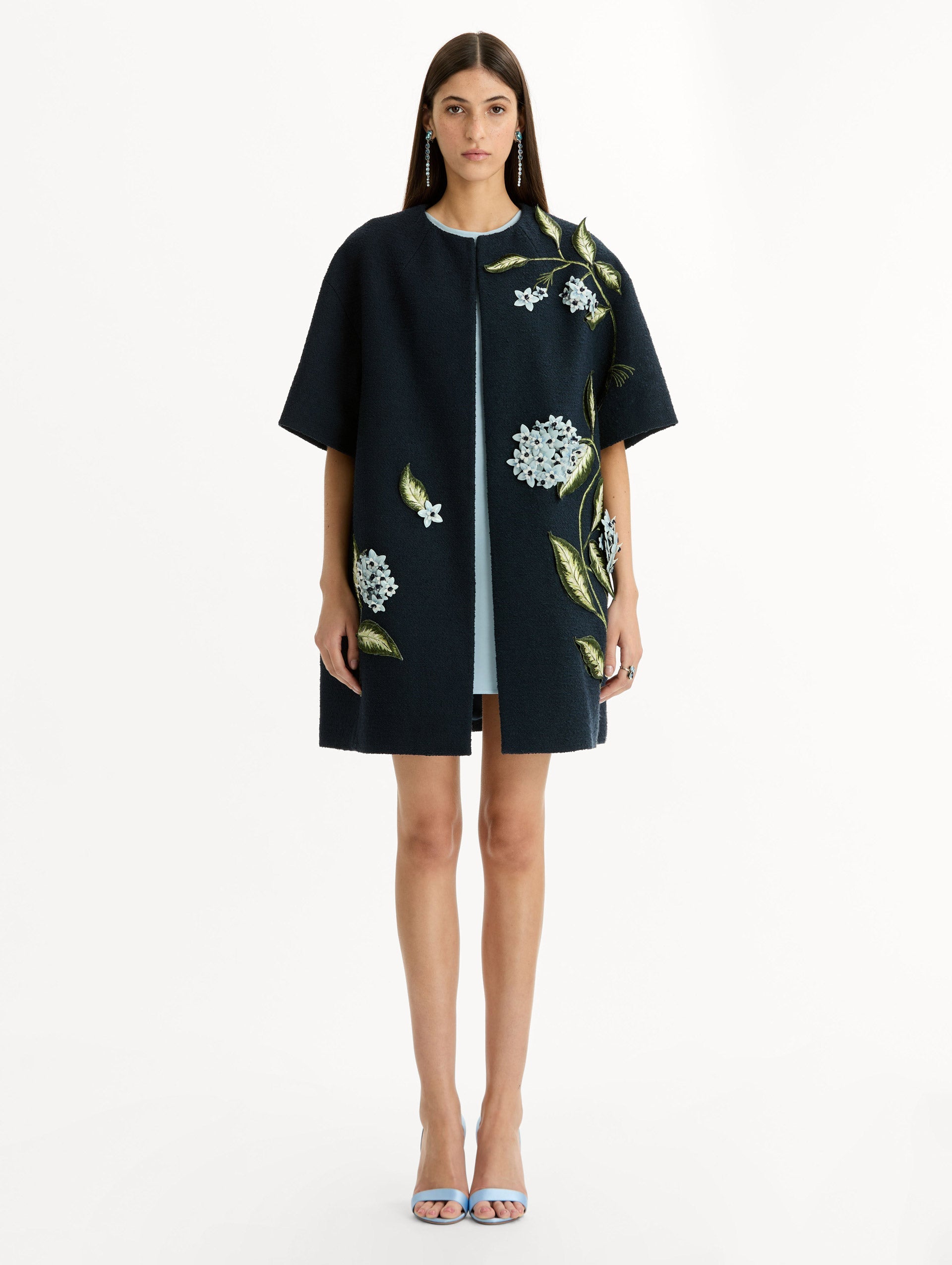 Short sleeve, navy tweed coat with porcelain flower embroidery. Floral motifs cascade across the front. Front View.